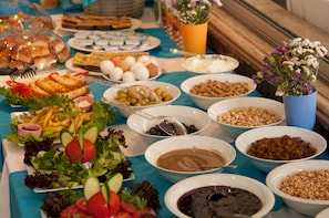 A buffet table with various food items including salads, fruits, and desserts.