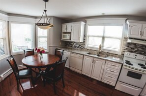 A kitchen with white cabinets, a granite countertop, a built-in microwave, a double sink, and a stove. - DOWNTOWN ST JOHN'S- CLEAN, off-street PARKING, patio, no hills (St. John's)