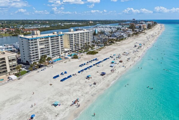 A beachfront hotel with multiple floors, a sandy beach, and a clear blue ocean. - Sand Castle 507: 2BD/2BA Beachfront Oasis (Indian Shores/Redington Shores)