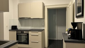 Una cocina compacta con estufa, horno y cafetera.