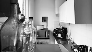A kitchen with a microwave, coffee maker, and a window.