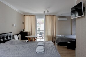 A hotel room with a bed, a desk, a chair, a TV, and a balcony. - Hotel Kalyan & Spa (Chisinau)