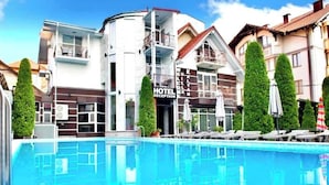 A hotel with a swimming pool, a reception area, and a sign indicating a hotel reception.
