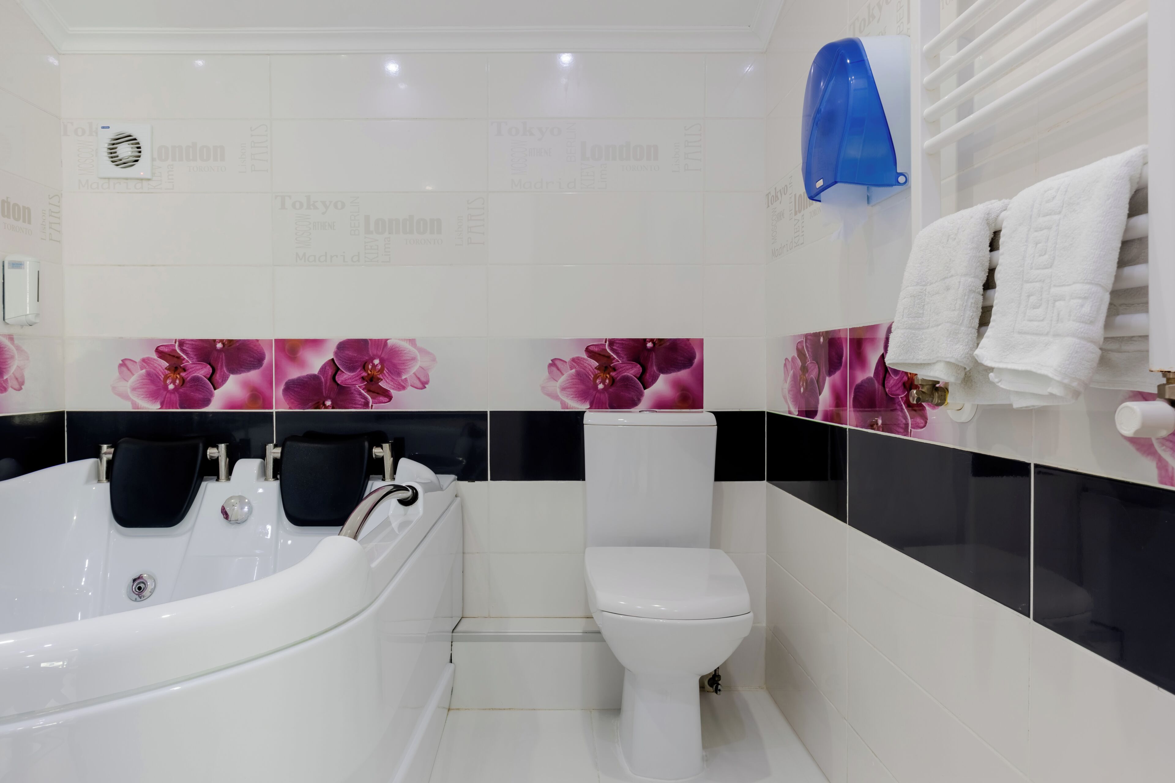 A modern bathroom with a freestanding bathtub, a toilet, and a towel rack.