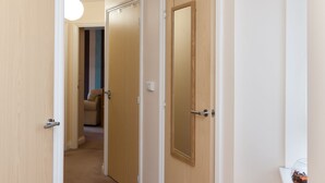 A hallway with wooden doors, a radiator, and a light fixture.
