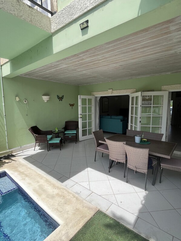 A covered patio with a pool, outdoor seating, and a kitchen area. - 'Palm View', West Coast 3 bd/3.5br villa with Private Pool *QUARANTINE APPROVED* (St James)