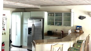A kitchen with a wooden ceiling, a stainless steel refrigerator, a toaster, and a fish-shaped wall decoration. - 'Palm View', West Coast 3 bd/3.5br villa with Private Pool walk to beach/bars  (St James)