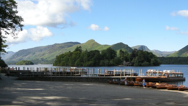 A lakeside dock with boats and a pier extending into the water, surrounded by green hills. - Keswick, Garden Apartment for 2. Excellent location.Convenient for all amenities (Keswick)