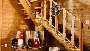 A wooden staircase with a decorative wreath and a gnome figure. There are two chairs and a small stool in the room. - Le Hygge Chalet Gerardmer 1-10 Pers (Anould)