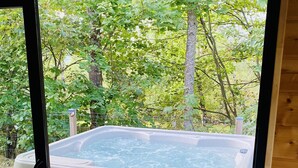 A hot tub on a wooden deck with a view of a forested area. - Le Hygge Chalet Gerardmer 1-10 Pers (Anould)
