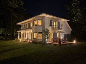 Une maison à deux étages dotée d’un balcon et d’un patio.