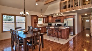 A spacious kitchen with wooden cabinets, a large island, and a dining area with a table and chairs.