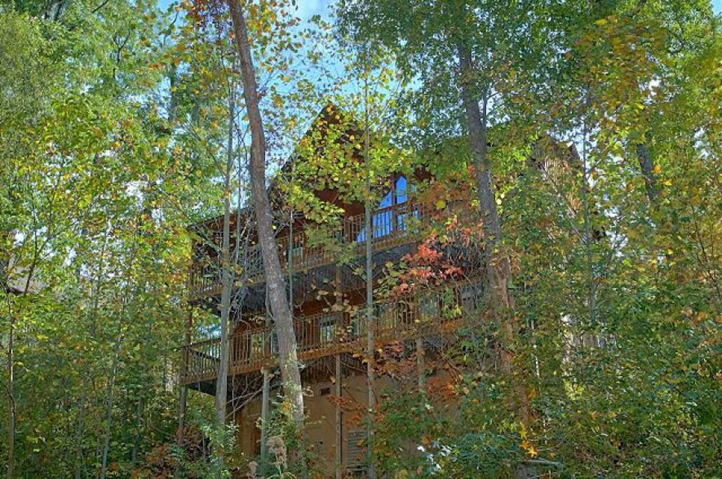 Un chalet en bois à plusieurs étages, entouré d’arbres.