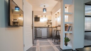 A modern kitchen with a dishwasher, refrigerator, and bar stools. - Ancient Agora Industrial Suite (Thessaloniki)