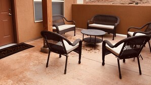 A patio with wicker furniture, a door, and a view of a mountain. - Red Sand Ridge. The best place to enjoy your vacation in Moab! (Moab)