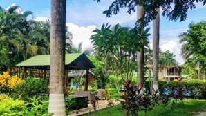 A lush garden with a gazebo, palm trees, and a pool area. - Explore Paradise-Palma Real cottage (Liberia)