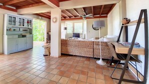 Una habitación con cama, escritorio, silla, lámpara y kitchenette.