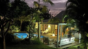 Un espacio exterior moderno con piscina, asientos y abundante vegetación.