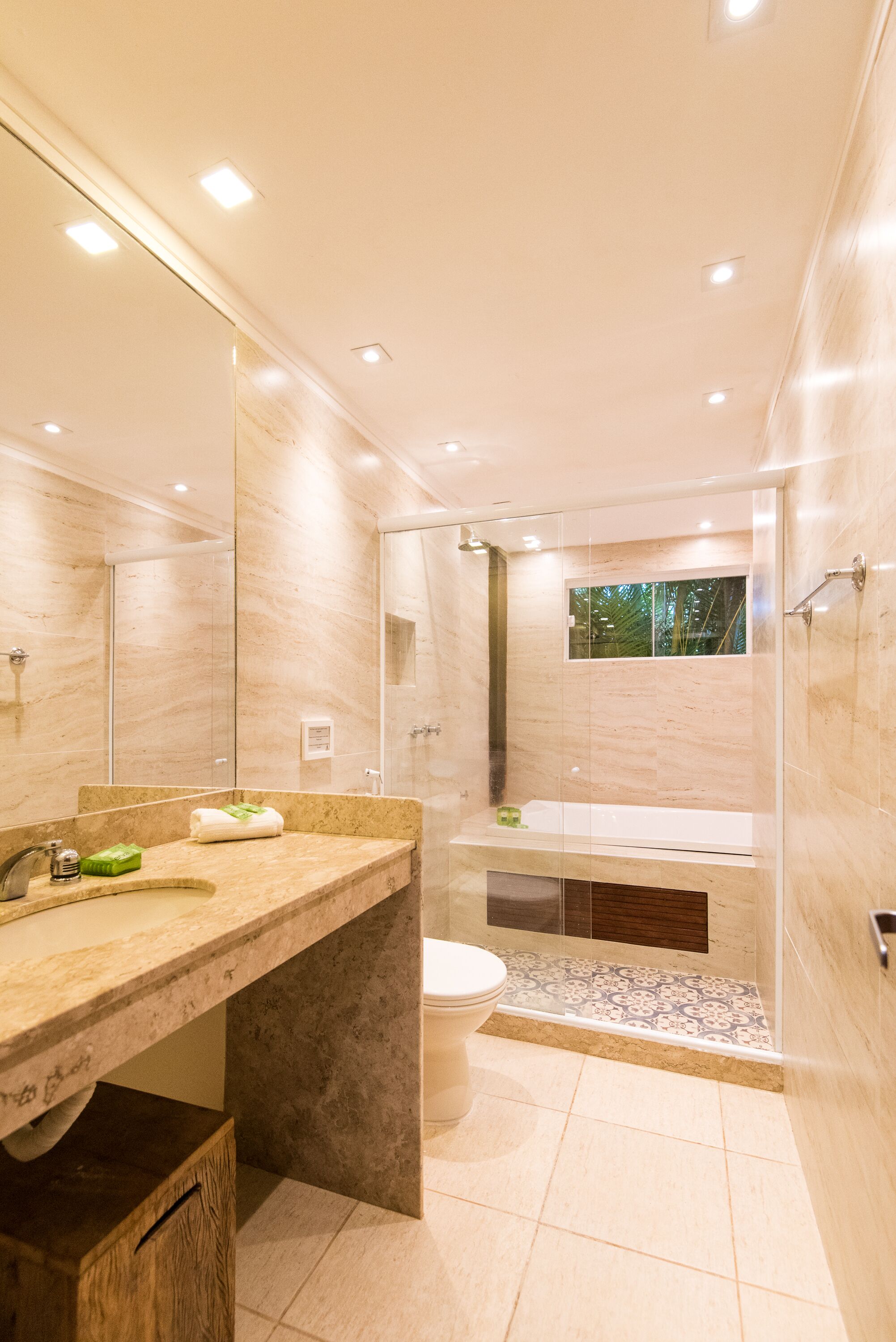 Une salle de bain moderne avec un grand miroir, un lavabo, des toilettes et un espace douche.