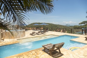 A pool area with a view of a mountain and a beach. - Pousada La Dolce Vita (Búzios)