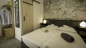 A hotel room with a bed, a wooden wardrobe, a mirror, and a wall-mounted light fixture. - Boutique accommodation Shappy (Zagreb)