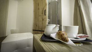 A breakfast setup with a croissant, a teapot, and a cup on a tray. - Boutique accommodation Shappy (Zagreb)