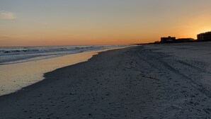 Ein Strand mit klarem Himmel und einem Sonnenuntergang.
