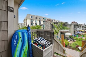 A residential building with a balcony, a water filtration system, and a view of neighboring buildings.