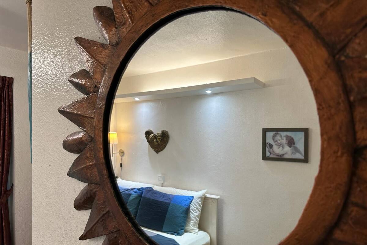 Una habitación con una cama, una decoración de corazón en la pared y un cuadro enmarcado.