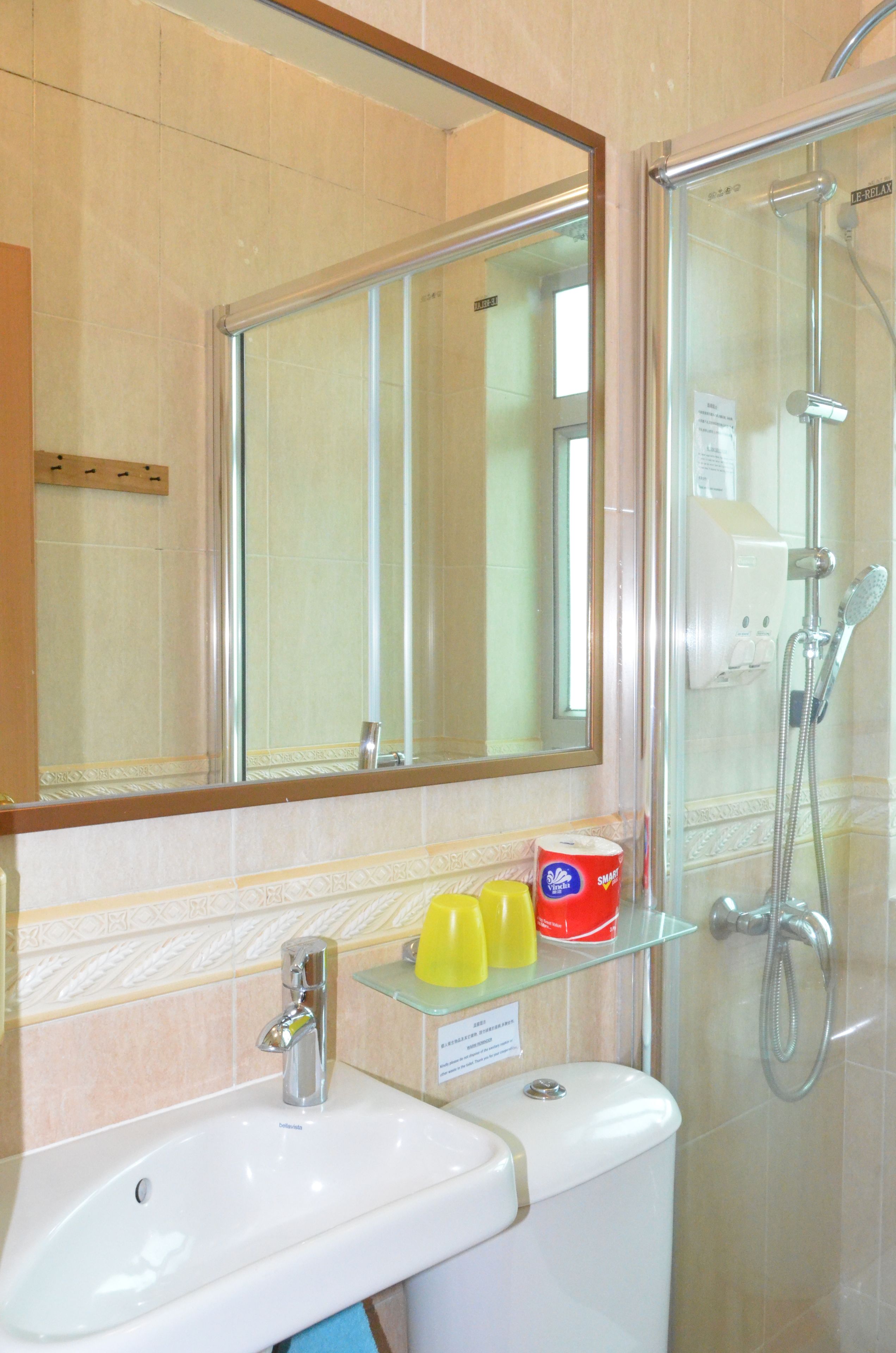 Un baño con lavabo, espejo y ducha.