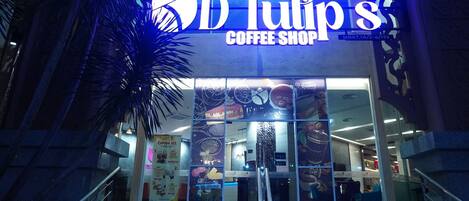 D'Tulip's Coffee Shop with a modern facade, large glass windows, and a visible staircase leading to the entrance.