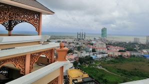 A view from a balcony overlooking a coastal cityscape with buildings, a bridge, and a construction crane. - Paya Bunga Hotel Terengganu (Kuala Terengganu)