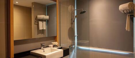 A modern bathroom with a glass-enclosed shower, a sink with a black countertop, and a mirror above the sink.