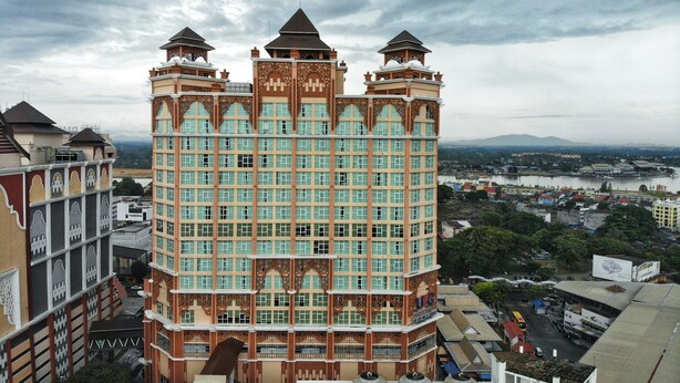 A multi-story hotel with a distinctive architectural design, featuring a central tower with decorative elements and multiple balconies. - Paya Bunga Hotel Terengganu (Kuala Terengganu)