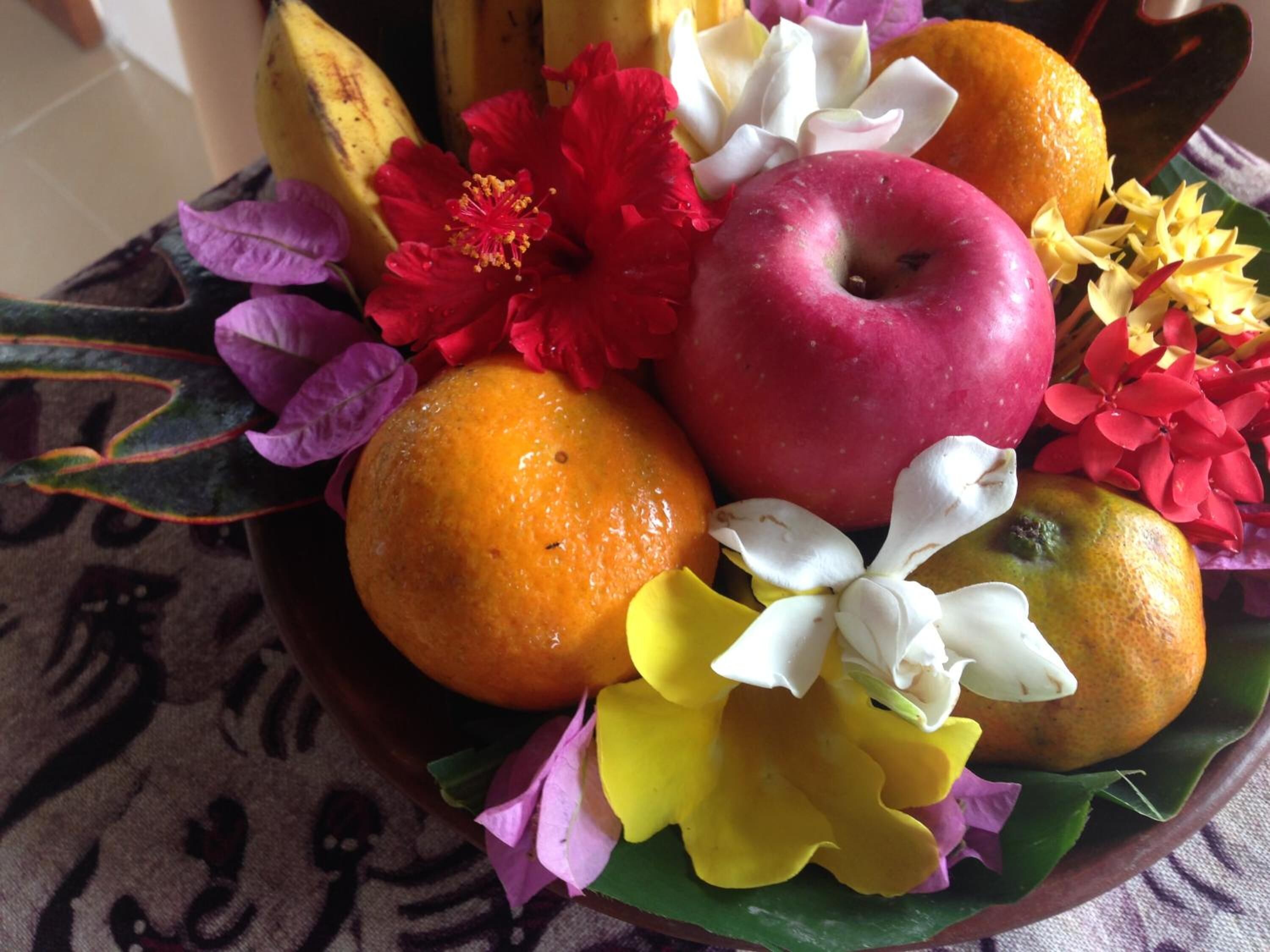 A bowl of fruit and flowers.