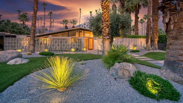 A modern house with a well-maintained garden, including palm trees and a variety of plants. - Mid-Century Modern Gem - Pool Spa Fire Pit w/ Stunning Views in Vista Las Palmas (Palm Springs)
