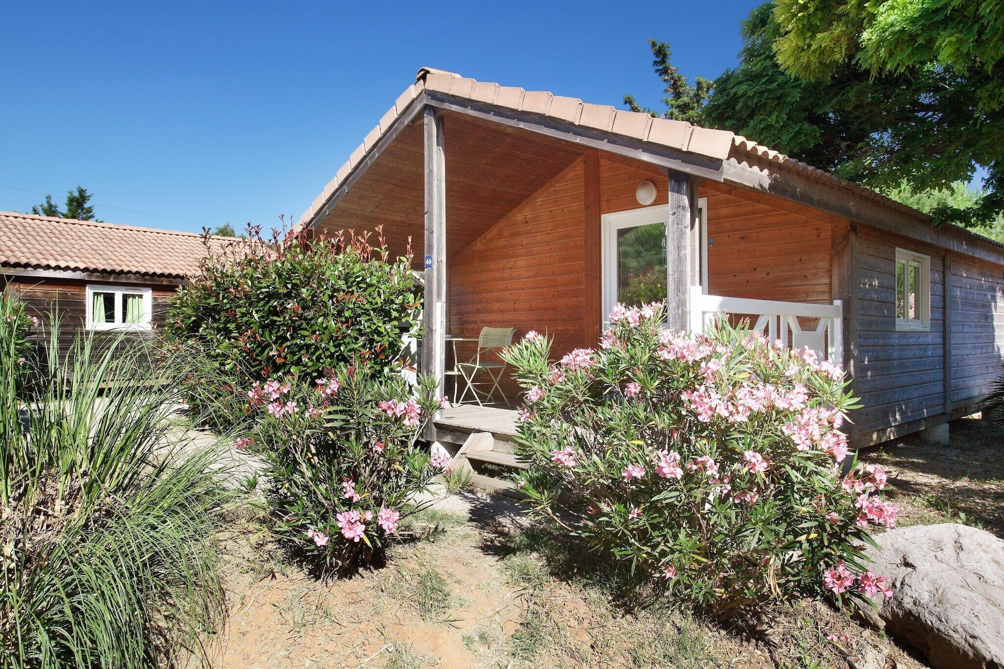 A wooden cabin with a covered porch, a door, and a window.