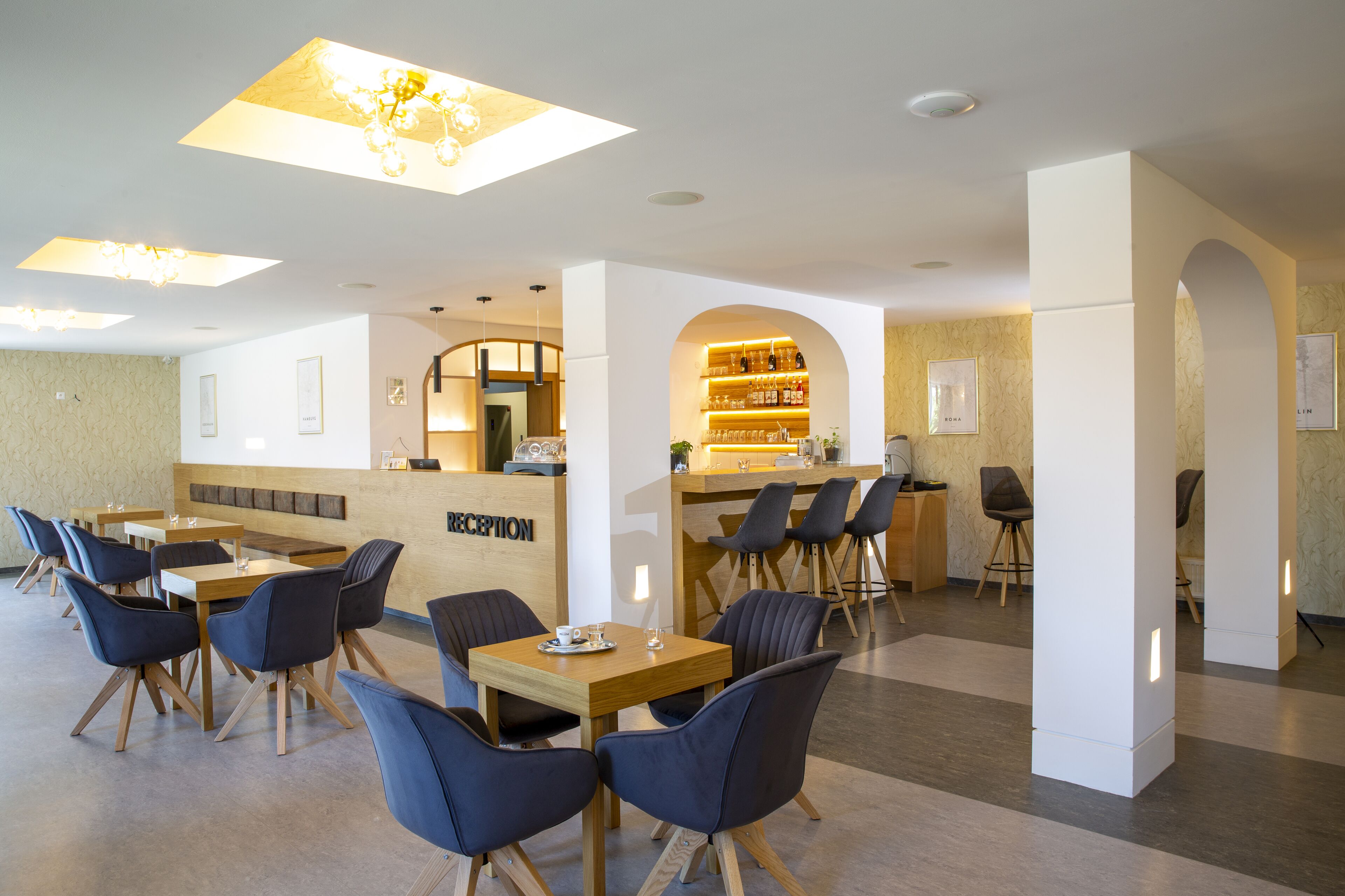 Eine moderne Hotelhalle mit Rezeption, Sitzgelegenheiten und einer Bar.