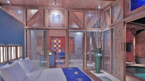 Ein Schlafzimmer mit einem Bett, einer großen Vase und Blick auf einen Pool.