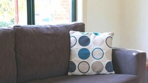Un canapé gris avec un coussin à motifs.