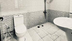 Un baño con inodoro, bidé y ducha.