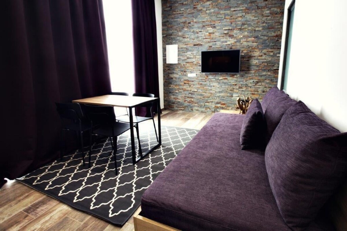 Une pièce moderne avec un canapé, une table et des chaises.