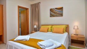 A neatly made bed with white and yellow bedding, a wooden headboard, and a bedside table with a lamp. - Delightful Coral Bay Villa,Large Pool, Billiard,Wonderful Area,Villas for Groups (CORAL BAY PAPHOS)