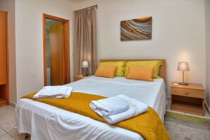 A neatly made bed with white and yellow bedding, a wooden headboard, and a bedside table with a lamp. - Delightful Coral Bay Villa,Large Pool, Billiard,Wonderful Area,Villas for Groups (CORAL BAY PAPHOS)