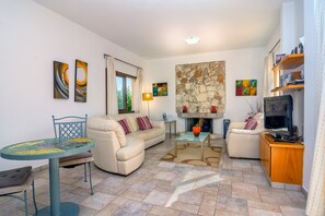 Télévision, cheminée, table de tennis de table, livres