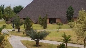 Un bâtiment doté d’un toit de chaume, entouré d’une pelouse bien entretenue et d’un chemin en béton menant à l’entrée.