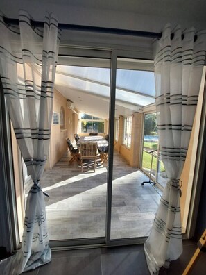 A room with a sliding glass door leading to an outdoor patio area with a table and chairs.