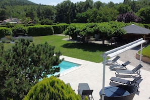 Uma área de piscina com espreguiçadeiras e um pérgola.