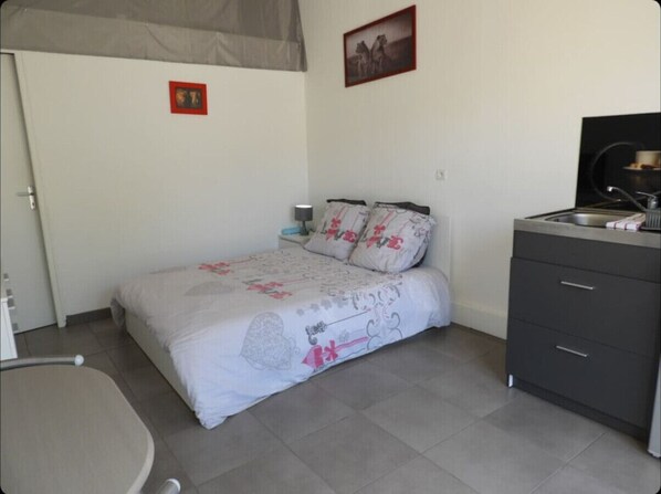 A bedroom with a bed, bedside table, and a wardrobe.