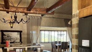 A kitchen with a central island, wooden cabinets, a refrigerator, and a dining area with a table and chairs. - Villa Ghjulia (Porto-Vecchio)
